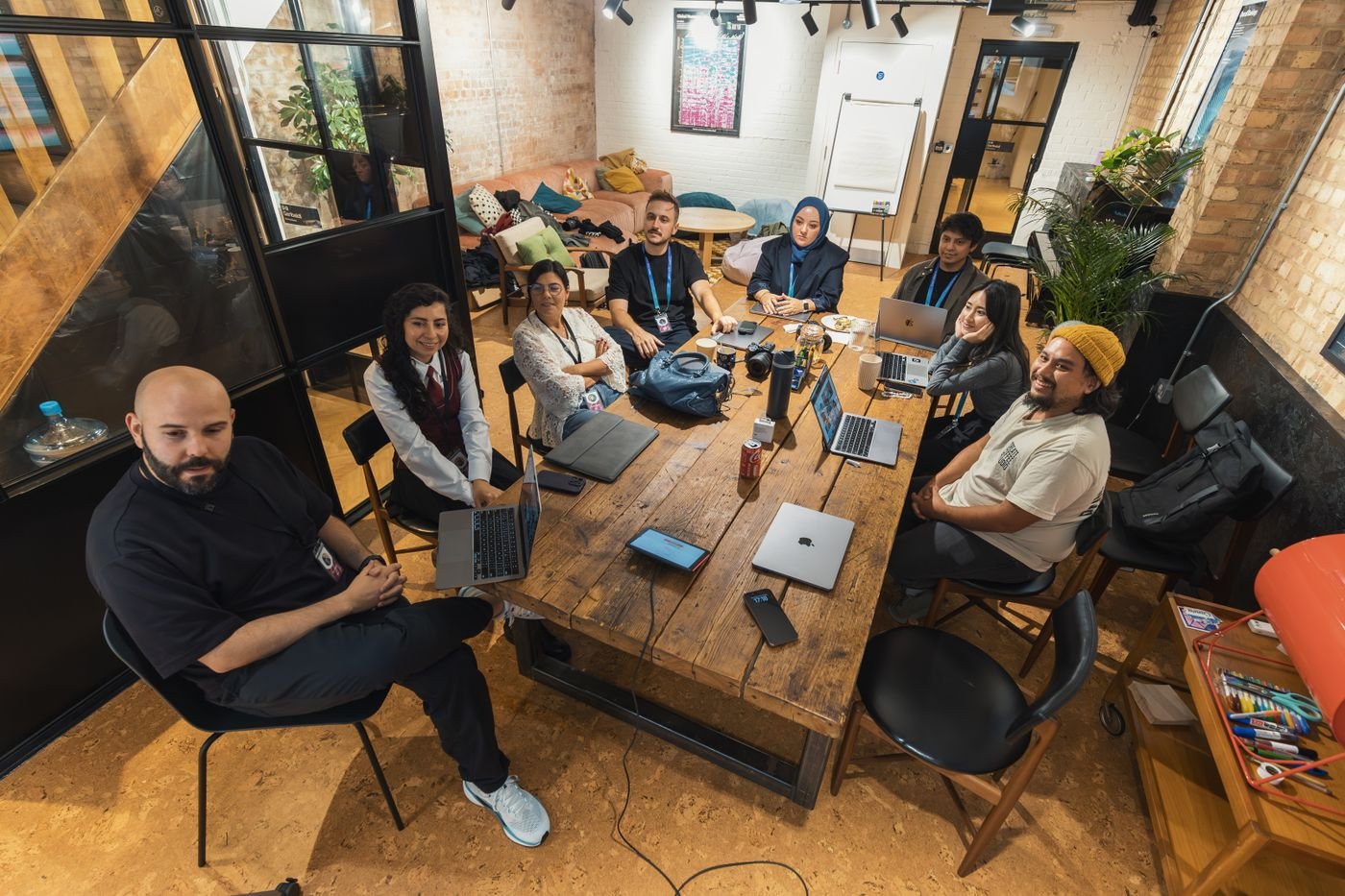A diverse team gathered with laptops in a modern coworking space